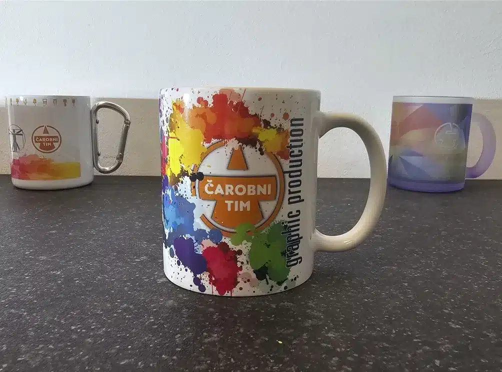 Bijela keramička šalica s punovojnim sublimacijskim otiskom logotipa i šarenim prskanjem boje