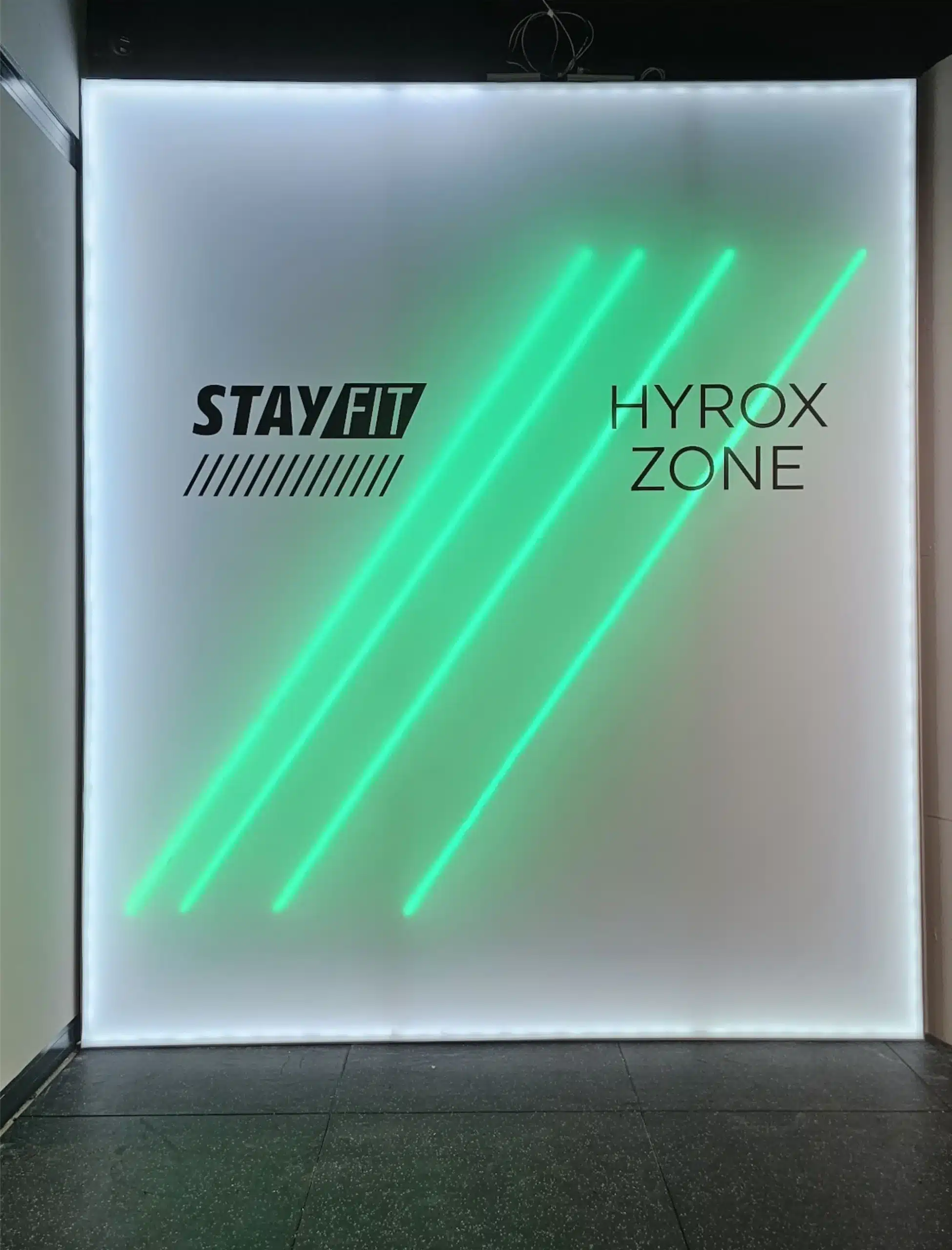 Svjetleća reklama panafex za teretanu StayFit Hyrox Zone sa zelenim neon elementima