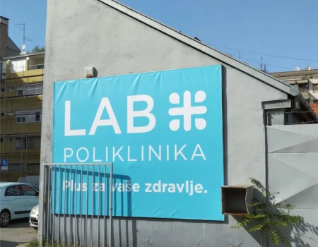 Reklamna cerada na fasadi s tiskom logotipa i poruke – veliki vanjski banner za zdravstvene i poslovne ustanove